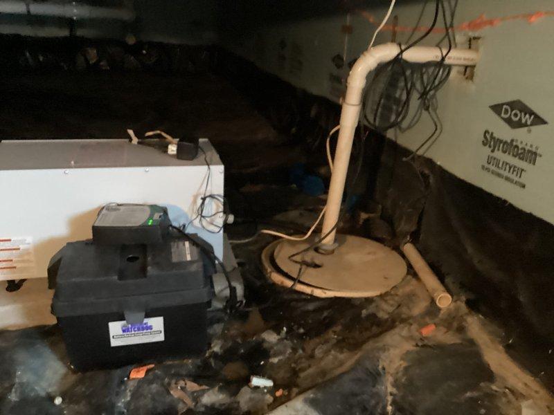 Responded to service call regarding improperly installed sump pump discharge piping from previous contractor's work. Upon arrival, inspected existing Basement Watchdog battery backup sump pump system with MarineMaster marine battery in crawl space. Documented current installation with photographs showing PVC discharge piping configuration, pump basin setup, and electrical connections. Assessed piping layout and system components to determine scope of corrections needed. Provided customer with detailed explanation of issues identified and presented options for proper remediation of discharge line installation to meet code requirements and ensure reliable system operation.