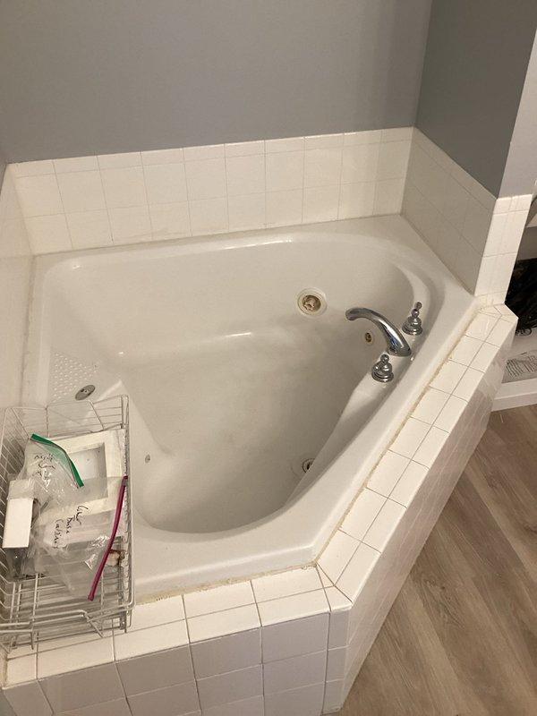 Completed comprehensive bathroom plumbing renovation including installation of kitchen sink drain assemblies with plastic tubular P-traps, end outlet waste connector, and flanged tailpiece. Installed chrome compression angle stop valves for water supply connections. Performed toilet reinstallation utilizing thin wax seals, brass adjustable closet bolts, stainless steel closet supply line, and Kohler tank-to-bowl gasket assembly. Configured water heater connections with brass fittings including tee, 90-degree elbow, and nipples of varying lengths, along with stainless steel flexible water heater connectors and aluminum drain pan for code compliance. All fixtures tested and verified operational upon completion.