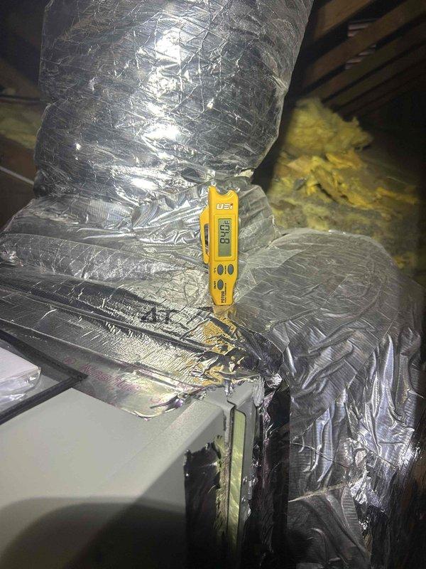 Responded to no cooling complaint on air handler system. Upon arrival, accessed attic space and located air handling unit with associated ductwork. Performed temperature diagnostics on supply duct system using digital thermometer, recording supply air temperatures of 80.8°F and 80.5°F at multiple measurement points. These elevated supply air temperatures confirmed lack of cooling operation and indicated system was circulating air without refrigeration cycle functioning properly. Documented conditions with photos showing ductwork configuration and temperature readings. Further diagnostics required to determine root cause of cooling failure, which may include compressor malfunction, refrigerant loss, electrical component failure, or control system issues.