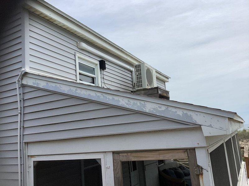 Provided estimate for complete mini split system replacement including one outdoor condensing unit and two indoor wall-mounted air handlers. System was originally installed by our company but ceased functioning after two years of operation and has remained inoperative despite previous service attempts. Assessed existing equipment locations in upstairs bedroom with wood paneling and exterior wall-mounted condenser on house siding. Documented current installation configuration and discussed replacement options with property owner to restore heating and cooling functionality to affected space.