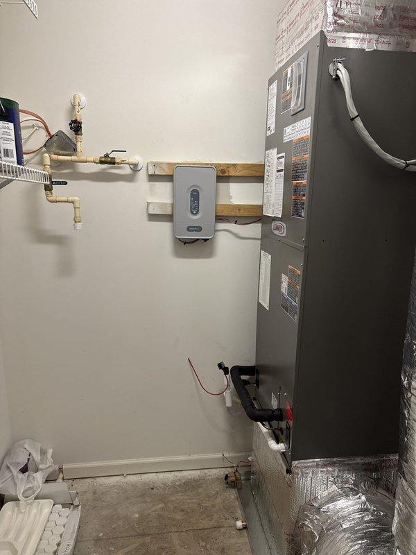 Completed full HVAC system replacement including removal and disposal of existing equipment. Installed Lennox EL19KPV-060 5-ton 19 SEER variable speed heat pump on exterior concrete pad with snow legs as requested. Indoor installation consisted of Lennox CBK45UHVT-060 variable speed air handler with 20 kW electric heat pack mounted in basement utility area. Fabricated and installed metal duct transitions to adapt new equipment to existing ductwork. Reused existing refrigerant lines and condensate drainage while replacing outdoor disconnect box and electrical whip to meet current code requirements. Installed Honeywell zone control board (1C1008K) with two Honeywell digital WiFi thermostats for multi-zone temperature management. All electrical connections completed and system tested for proper operation across all zones. Verified refrigerant charge, airflow, and heating/cooling capacity meet manufacturer specifications.