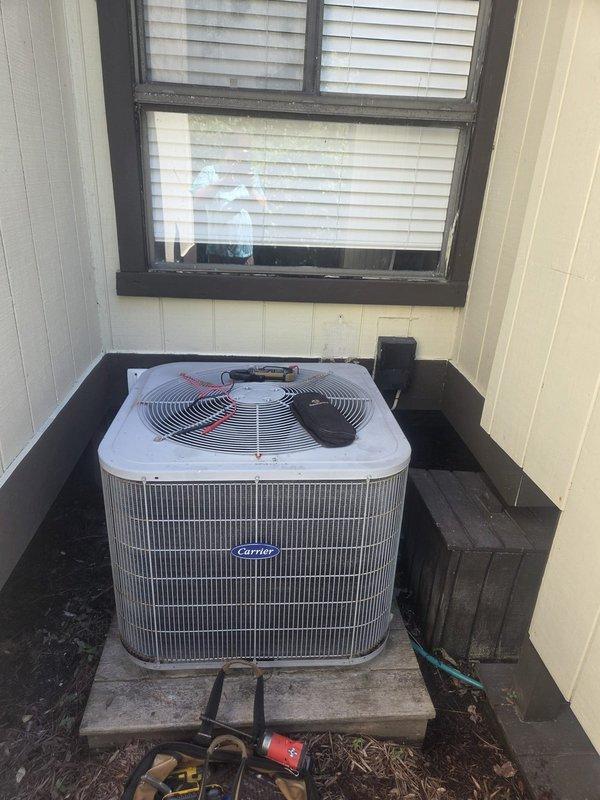 # HVAC Service Report - No Cooling Complaint

Responded to service call for Carrier split system air conditioning unit with no cooling condition. Upon arrival, conducted diagnostic evaluation of outdoor condenser unit and indoor air handler located in laundry closet.

Performed visual inspection of outdoor condenser unit positioned on concrete pad. Observed unit configuration with refrigerant lines running to interior air handler. Checked electrical connections, capacitor operation, and compressor functionality. Verified fan motor operation and inspected condenser coil condition for airflow restrictions or debris accumulation.

Proceeded to indoor air handler unit mounted above laundry appliances. Inspected air handler components including blower motor, evaporator coil access, and refrigerant line connections. Evaluated thermostat communication and system control board operation. Checked air filter condition and airflow through return and supply ductwork.

Conducted refrigerant pressur