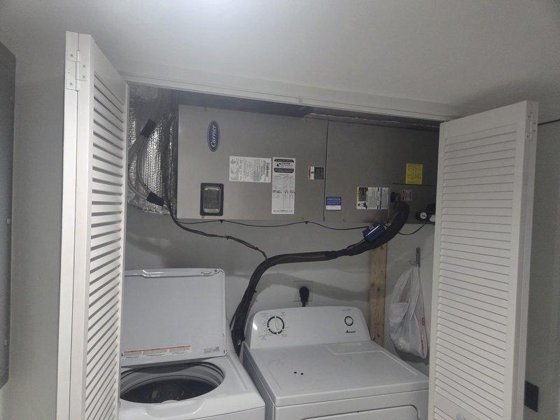 # HVAC Service Report - No Cooling Complaint

Responded to service call for Carrier split system air conditioning unit with no cooling condition. Upon arrival, conducted diagnostic evaluation of outdoor condenser unit and indoor air handler located in laundry closet.

Performed visual inspection of outdoor condenser unit positioned on concrete pad. Observed unit configuration with refrigerant lines running to interior air handler. Checked electrical connections, capacitor operation, and compressor functionality. Verified fan motor operation and inspected condenser coil condition for airflow restrictions or debris accumulation.

Proceeded to indoor air handler unit mounted above laundry appliances. Inspected air handler components including blower motor, evaporator coil access, and refrigerant line connections. Evaluated thermostat communication and system control board operation. Checked air filter condition and airflow through return and supply ductwork.

Conducted refrigerant pressur