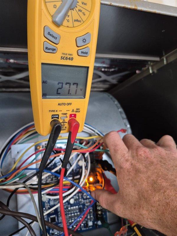 Responded to no cooling call with reported fan motor not operating. Upon arrival, performed electrical diagnostics on the air handler control board and terminal connections. Utilized multimeter to test voltage at various connection points, measuring 27.7 VAC at control terminals. Inspected wiring harness, terminal block connections, and control board components to identify cause of blower motor failure and restore cooling operation.