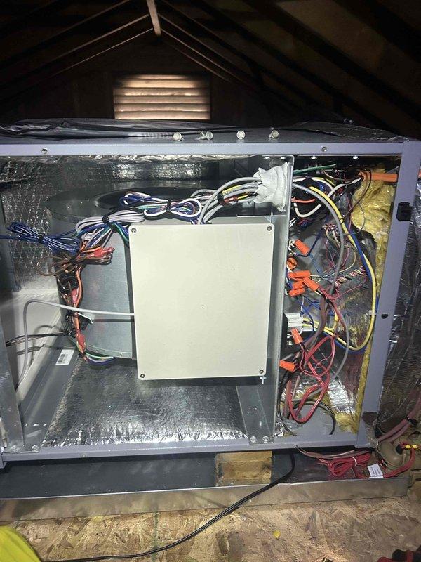 Responded to no cooling complaint on second floor geothermal system with inadequate airflow. Unit was reading 84°F against 78°F setpoint with 60% relative humidity. Upon inspection, accessed air handler in attic space and examined internal components including heat exchanger coil, blower motor assembly, and control wiring. Photographed serpentine heat exchanger showing clean coil surfaces and blower motor configuration. Documented control box and electrical connections for diagnostic purposes. Advised system be turned off temporarily to prevent compressor damage while operating without proper airflow.