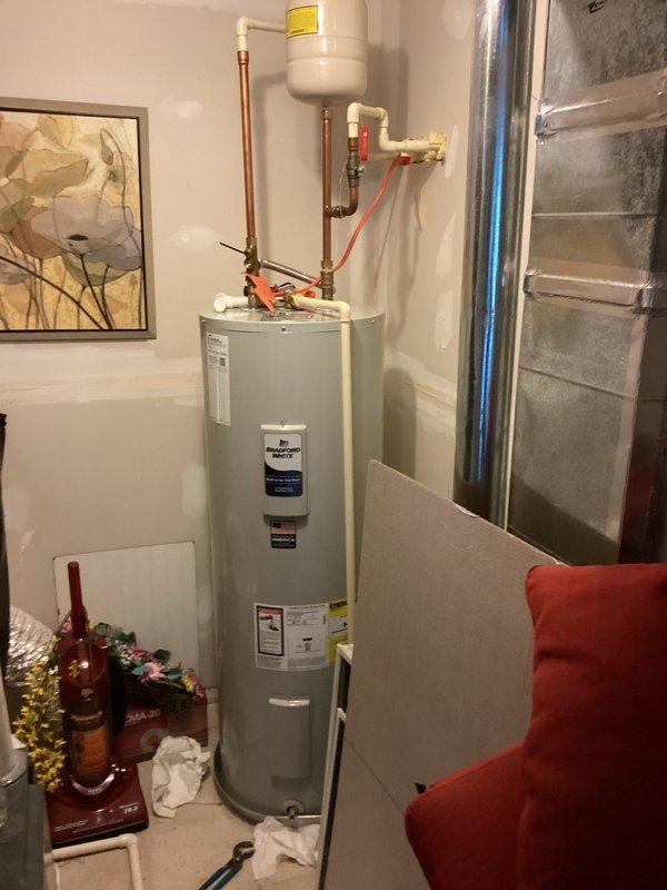 Completed recurring maintenance visit on residential tanked water heater. Performed comprehensive inspection of unit, including evaluation of temperature and pressure relief valve, copper supply lines, brass fittings, and expansion tank mounted above heater. Verified proper operation of all plumbing connections and safety components. Documented equipment condition with photographs for service records. Unit found to be functioning within normal parameters with all components properly secured and operational.