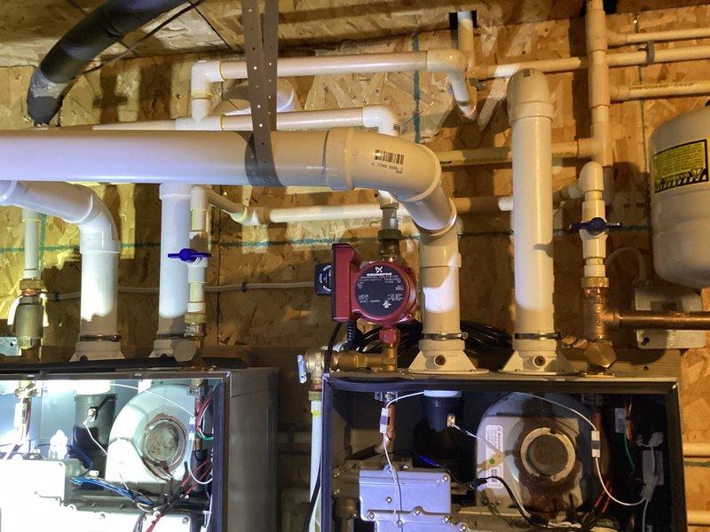 Completed scheduled tankless water heater maintenance visit as part of recurring service agreement. Performed comprehensive inspection of tankless unit, circulator pump, and associated plumbing connections in basement mechanical room. Verified proper operation of system components including red circulator pump, isolation valves, PVC supply and return lines, and copper piping connections. All equipment found operating within normal parameters with no leaks or deficiencies noted at time of inspection.