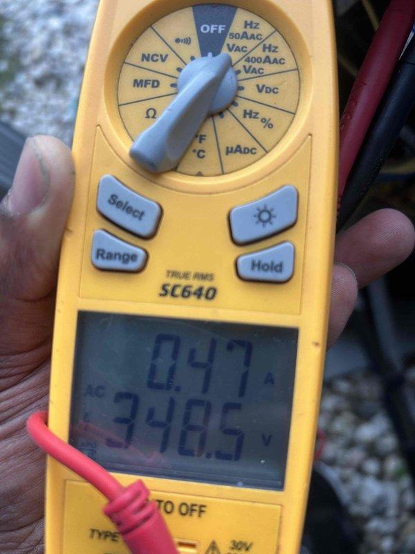# HVAC Emergency Service - No Cooling Condition

Responded to emergency no-cool call on 10+ year old Trane air handler system. Upon arrival, performed diagnostic testing of electrical components using digital multimeter. Measured operating voltage at 348.5V and current draw at 0.47A to assess system performance. Inspected equipment installation in basement mechanical room, noting air handler mounted in metal framework alongside water heater. Verified unit specifications and reviewed maintenance labeling indicating 16x30 filter requirement with 30-day change interval. Documented equipment condition and diagnostic findings with photographic evidence. System evaluated for age-related component failure and cooling capacity issues typical of older HVAC installations.