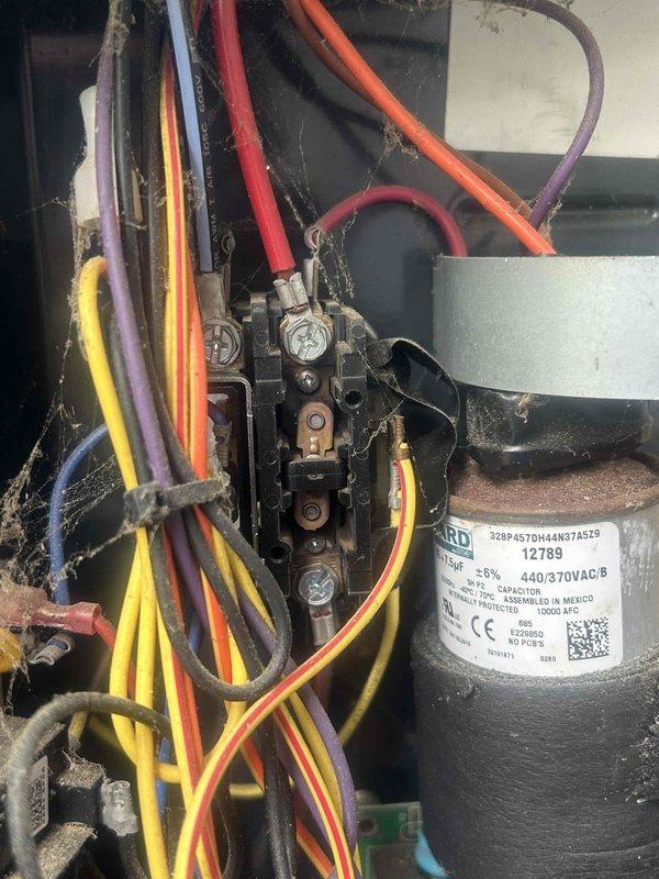 # Emergency No Cooling Call - 10+ Year Old System

Responded to emergency service call for air conditioning system with no cooling. Upon arrival, performed diagnostic evaluation of approximately 10-year-old HVAC unit. Inspected electrical control panel and contactor assembly, noting significant accumulation of dust, debris, and cobwebs throughout the system components indicating extended service period without maintenance.

Examined electrical connections at contactor assembly, verifying integrity of multi-colored wire bundle connections to terminal blocks. Tested 440/370VAC dual-run capacitor for proper microfarad readings and voltage specifications. Inspected all wire terminations at contactor screws and terminal points for tightness and signs of overheating or deterioration.

Evaluated contactor operation, checking for proper contact closure and signs of pitting or wear on copper contact points. Assessed overall electrical component condition within control panel, including circuit 