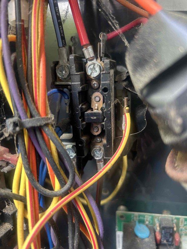 # Emergency No Cooling Call - 10+ Year Old System

Responded to emergency service call for air conditioning system with no cooling. Upon arrival, performed diagnostic evaluation of approximately 10-year-old HVAC unit. Inspected electrical control panel and contactor assembly, noting significant accumulation of dust, debris, and cobwebs throughout the system components indicating extended service period without maintenance.

Examined electrical connections at contactor assembly, verifying integrity of multi-colored wire bundle connections to terminal blocks. Tested 440/370VAC dual-run capacitor for proper microfarad readings and voltage specifications. Inspected all wire terminations at contactor screws and terminal points for tightness and signs of overheating or deterioration.

Evaluated contactor operation, checking for proper contact closure and signs of pitting or wear on copper contact points. Assessed overall electrical component condition within control panel, including circuit 