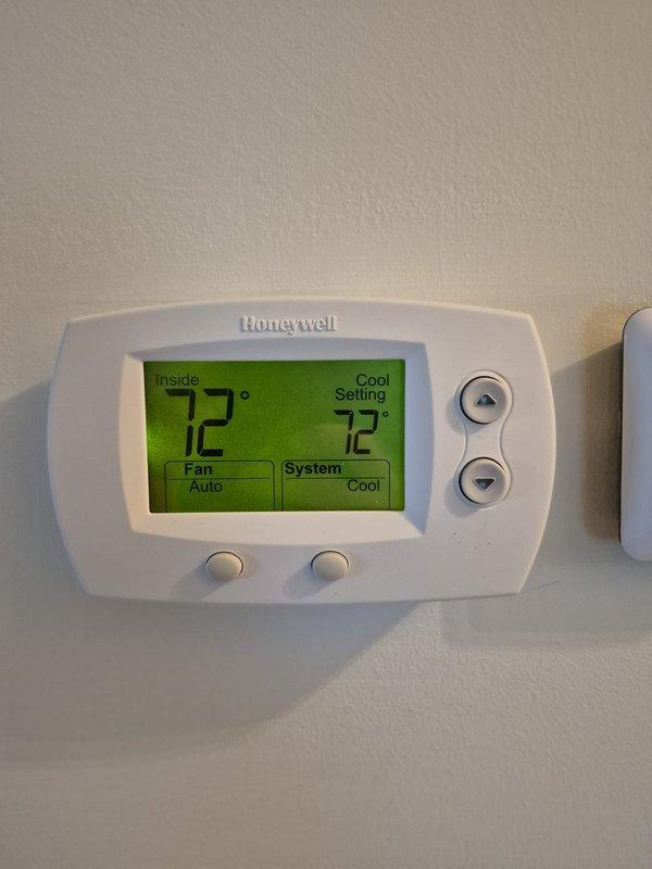 Arrived on-site for scheduled cooling maintenance visit on two HVAC systems. Customer was not present after 15-minute wait period, and multiple contact attempts via phone were unsuccessful with voicemails left on all available numbers. Documented electrical readings on outdoor condensing unit showing 6.19V and 0.4A using digital multimeter, and verified thermostat operation displaying 72°F indoor temperature with system set to cooling mode and fan on auto setting.