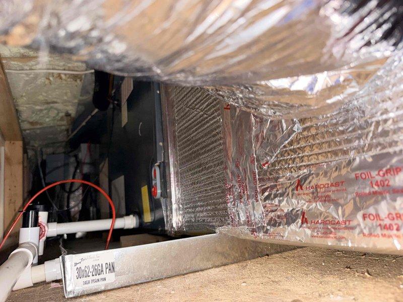 Responded to service call for non-operational main level HVAC system. Performed comprehensive assessment of outdoor condensing unit showing signs of age and wear, including discoloration and dirt accumulation on exterior surfaces. Evaluated indoor evaporator coil assembly in attic space, inspecting foil-wrapped coil unit, galvanized drain pan, and PVC condensate drainage system for proper operation and potential failure points. Documented equipment condition through photographic evidence to support replacement estimate for aging system components.