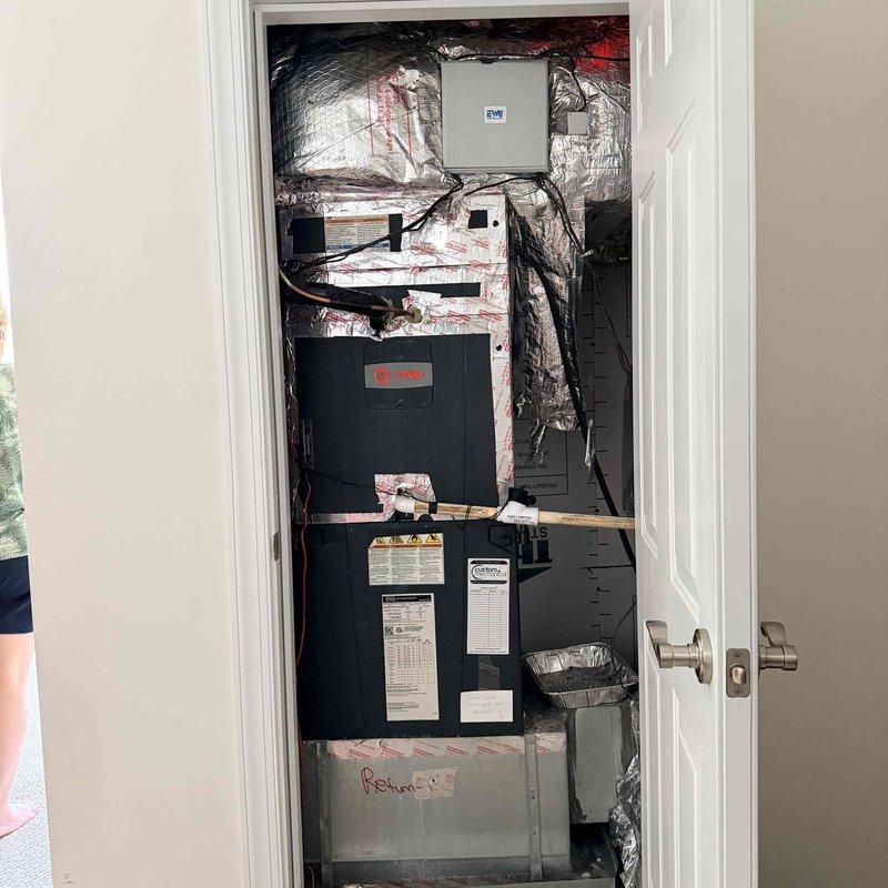 Assessed 14-year-old HVAC system with failed compressor located in interior utility closet. Documented existing vertically-stacked air handler unit with associated ductwork, electrical connections, and Honeywell digital thermostat control. Provided replacement system estimate as repair costs were determined to be prohibitive given equipment age and component failure.