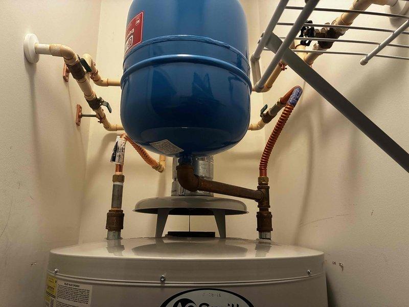 Conducted initial assessment and provided estimate for gas water heater replacement. Unit is an A.O. Smith model located in first-floor laundry room with easy access. Current system includes expansion tank mounted above water heater with copper supply lines and flexible connector hoses. Documented existing installation configuration including piping connections, control valve assembly, and electrical conduit routing for replacement planning.