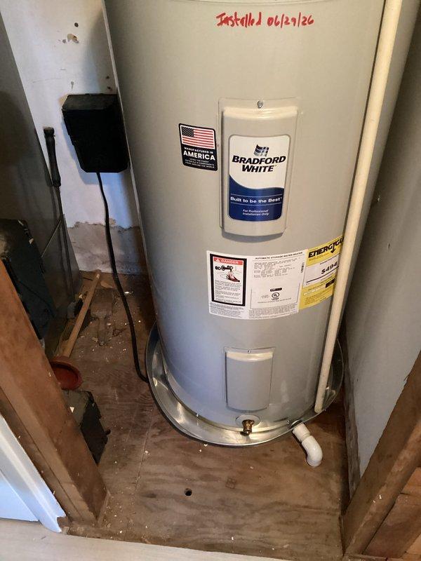 Accessed property via lockbox and coordinated with ongoing remodeling work that provided improved access to the water heater location behind the HVAC air handler. Verified power was disconnected to the existing electric water heater, drained the tank completely, and disconnected all plumbing and electrical connections. Removed and properly disposed of the old water heater unit. Staged the new 50-gallon Bradford White electric water heater (model RE250S61) with 24-inch drain pan, expansion tank, brass fittings (3/4" x 2" nipple, 3/4" x 6" nipple, 3/4" 90-degree elbow, 3/4" tee), and two 18-inch flex connectors in the dining room pending completion of remodeling work. Confirmed the new 22-inch diameter tank would fit through the 25-inch stud opening in the hallway. Coordinated with property owner to schedule final installation upon completion of contractor work. Returned to complete installation once remodeling allowed proper access. Installed new Bradford White 50-gallon electric water 