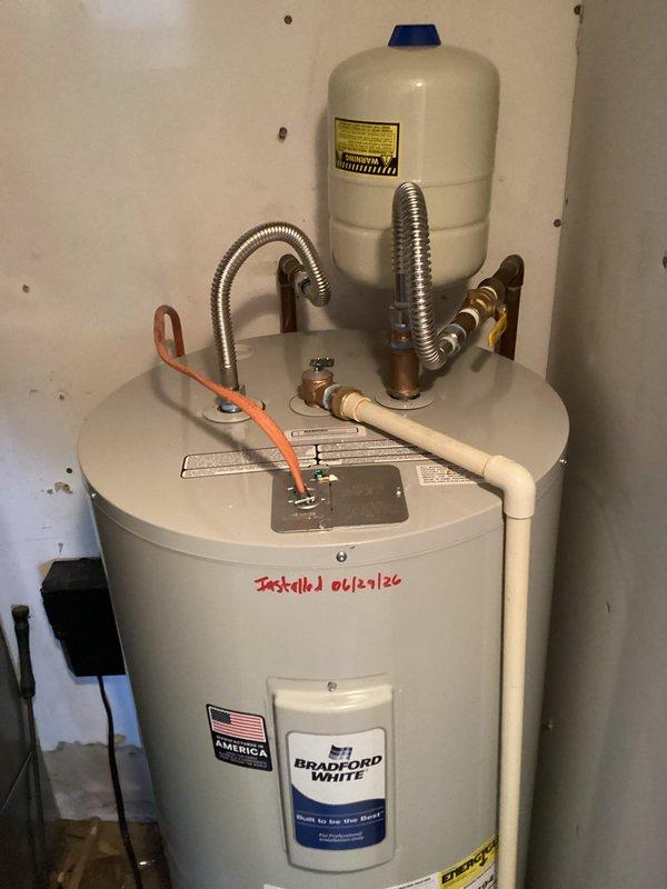 Accessed property via lockbox and coordinated with ongoing remodeling work that provided improved access to the water heater location behind the HVAC air handler. Verified power was disconnected to the existing electric water heater, drained the tank completely, and disconnected all plumbing and electrical connections. Removed and properly disposed of the old water heater unit. Staged the new 50-gallon Bradford White electric water heater (model RE250S61) with 24-inch drain pan, expansion tank, brass fittings (3/4" x 2" nipple, 3/4" x 6" nipple, 3/4" 90-degree elbow, 3/4" tee), and two 18-inch flex connectors in the dining room pending completion of remodeling work. Confirmed the new 22-inch diameter tank would fit through the 25-inch stud opening in the hallway. Coordinated with property owner to schedule final installation upon completion of contractor work. Returned to complete installation once remodeling allowed proper access. Installed new Bradford White 50-gallon electric water 