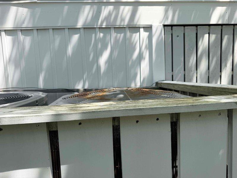 Performed HVAC system evaluation on 14-year-old Carrier unit located in coastal environment. Added refrigerant and UV dye to system to facilitate leak detection. Recommended complete system replacement due to advanced age, deteriorated condition from salt air exposure, and active refrigerant leak. Documented equipment measurements and captured photographic evidence of existing dual condenser installation on elevated wooden platform showing significant weathering from oceanfront conditions.