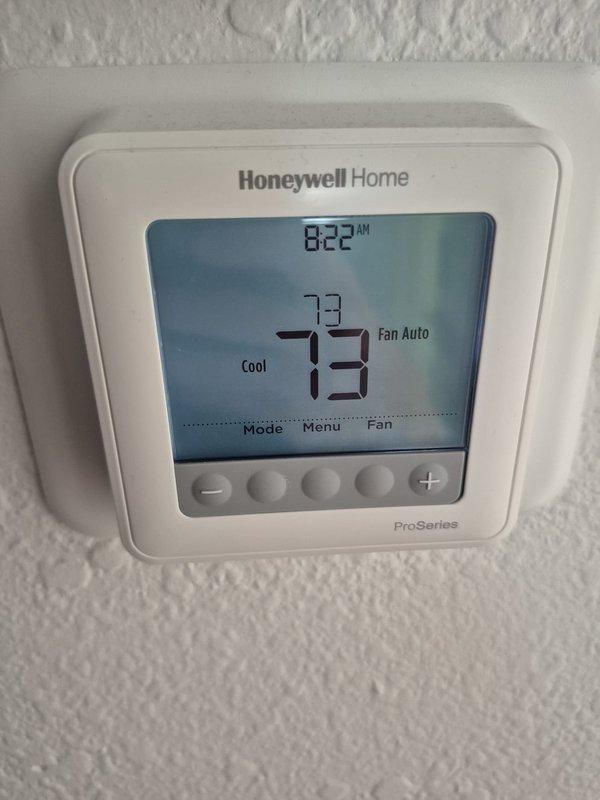 Completed preventative maintenance cooling inspection on residential HVAC system. Verified Honeywell ProSeries thermostat operation showing 73°F set point with system in cooling mode and fan set to auto. Performed electrical diagnostics using clamp meter, measuring current draw at 0.95 amps with system operating within normal parameters. Inspected air handler components, capacitor, and electrical connections, confirming all equipment functioning properly with no issues found.