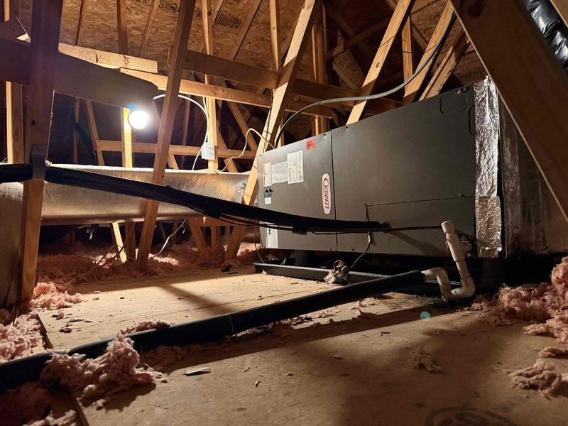 Evaluated 18-year-old upstairs HVAC system operating on R-22 refrigerant and found refrigerant charge critically low. Assessed attic-mounted air handler unit and associated ductwork, determining complete system replacement necessary due to age and obsolete refrigerant type. Documented existing electrical panel configuration and downstairs HVAC equipment for comprehensive replacement quote preparation, providing multiple equipment options for both upstairs full system replacement and downstairs air conditioning component replacement.