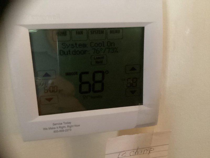 Performed estimate for complete HVAC system replacement located in bedroom closet utility space where water heater is also housed. System diagnosed with refrigerant leak requiring full unit replacement. Documented existing thermostat displaying 68°F with system in cooling mode and outdoor conditions at 75°F/75% humidity, as well as photographed confined closet access area with tiled flooring for replacement planning and equipment specifications.
