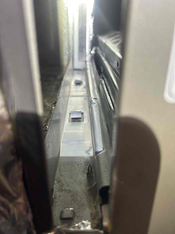 Responded to service call for newly installed heat pump system with water accumulation in return duct. Upon inspection, documented condensate drain pan and drainage system components to verify proper installation and water management. Photographed internal HVAC components including drain pan with visible drain ports, confirming drainage pathways are clear and functional to prevent future water intrusion into ductwork.