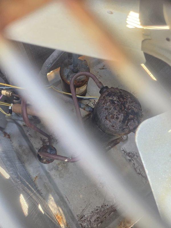 Responded to emergency no-cooling call where system was completely non-operational. Upon arrival, accessed outdoor condensing unit and discovered severely corroded compressor with extensive rust deterioration and surface degradation. The compressor's advanced corrosion state indicated complete failure, rendering the unit inoperable. Documented equipment condition with photographs showing the deteriorated compressor, refrigerant lines, and associated components. Customer was informed that the compressor failure requires unit replacement due to the extent of damage and age-related deterioration of the system.