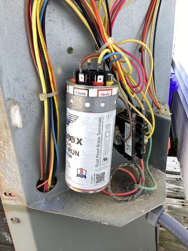 Responded to emergency no-cooling call on older residential air conditioning system. Upon arrival, confirmed complete system failure with no power to outdoor condensing unit. Performed diagnostic evaluation of electrical components and identified failed dual-run capacitor as root cause of system outage. Capacitor tested at 7.5/10 MFD showed zero capacitance on both common and hermetic terminals, preventing compressor and condenser fan motor operation. Replaced defective capacitor with properly rated OEM equivalent unit, verified all electrical connections at contactor and terminal block, and restored power to system. Cycled unit through complete startup sequence, confirmed compressor engagement, verified proper condenser fan operation, and tested system amperage draw within manufacturer specifications. System returned to normal cooling operation with no further issues observed.