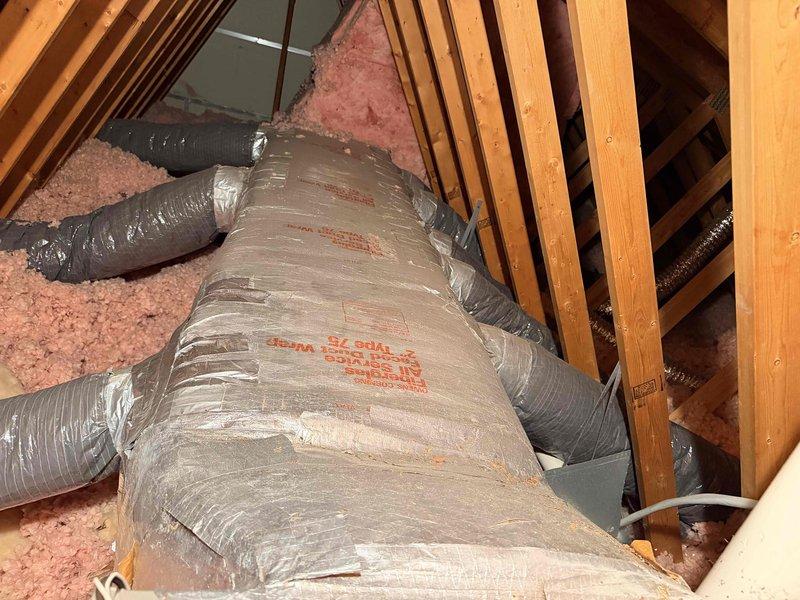 Performed site assessment on 16-year-old HVAC system located in attic space. Identified evaporator coil with active refrigerant leak in nonrepairable location, accompanied by severe rust deterioration. Documented existing equipment condition including air handler unit, flexible ductwork system, and associated components through photographic evidence. Recommended complete system replacement due to age of equipment, extent of coil corrosion, and non-viable repair options.