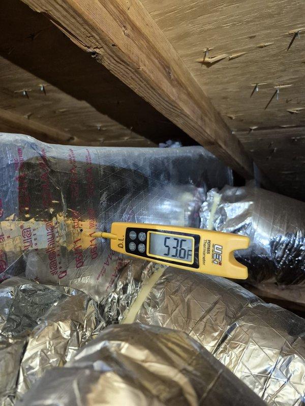 Completed scheduled cooling maintenance visit on residential HVAC system. Accessed attic-mounted equipment and performed temperature diagnostics on supply ductwork, recording 53.6°F at supply plenum and 25.1°F differential measurements to verify proper system operation. Inspected ductwork insulation integrity, confirmed all flexible ducts properly sealed with foil jacketing, and verified adequate fiberglass insulation coverage throughout attic space. System operating within normal parameters with appropriate temperature split across evaporator coil.
