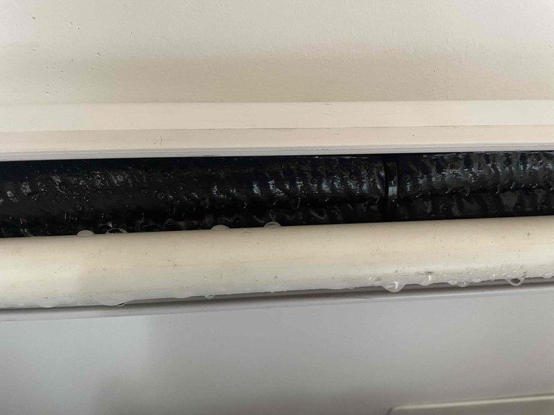 Responded to recurring condensate leak issue with water running down interior walls from mini split system. Upon inspection, found excessive moisture accumulation on refrigerant lines and condensate drainage components, indicating improper drainage or blockage in the condensate removal system. Documented conditions with photos showing water droplets forming on both insulated and uninsulated piping within the line set chase, confirming active condensation problem requiring immediate attention to prevent further water damage and customer dissatisfaction.