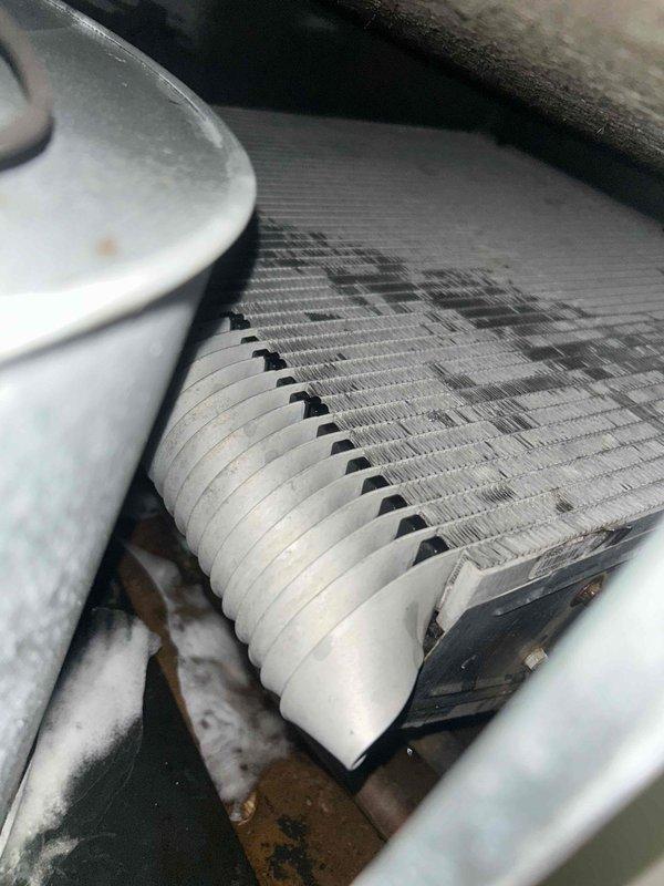 Responded to no cooling complaint on residential HVAC system. Upon inspection, found evaporator coil showing signs of restricted airflow with visible debris accumulation on fin surfaces. Examined refrigerant lines and condensate drainage system in attic installation - all connections secure with no visible leaks. Documented system conditions with photos showing coil contamination and ductwork configuration. Customer advised system not maintaining temperature setpoint due to reduced airflow across evaporator coil, requiring additional service to restore proper cooling capacity.