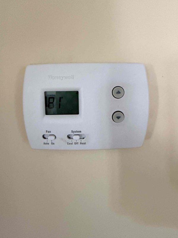 Performed diagnostic evaluation on 16-year-old residential HVAC system with critically low refrigerant charge. System found to be nearly flat, indicating potential coil leak or system failure. Customer declined refrigerant recharge and requested multiple replacement estimates including isolated coil replacement, air conditioning components only (indoor and outdoor coils), and complete system replacement options. Documented existing Daimons furnace installation in attic space with current Honeywell thermostat displaying 87°F, photographed equipment and configuration for estimate preparation.