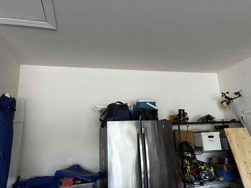Conducted on-site assessment for tankless water heater installation in residential garage. Evaluated existing space configuration and determined optimal routing for flue pipe system, which will run along exterior of drywall on pit side of garage to ensure proper venting and code compliance. Documented current equipment layout including existing water heater and surrounding storage areas to plan installation pathway and clearance requirements.