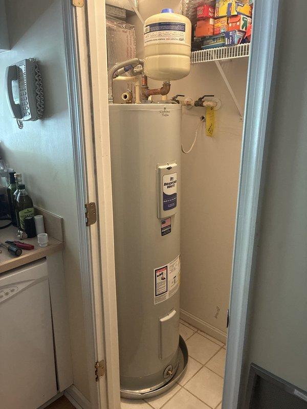 Installed 50-gallon tall Bradford White residential water heater (model RE250T6) in utility closet. Installation included 22-inch drain pan, thermal expansion tank, brass fittings (3/4" x 3" and 3/4" x 6" nipples, 90-degree elbow, tee), dual 18-inch flexible water connectors, and high-temperature rated 3/4" male adapters. Configured all plumbing connections with copper piping, installed temperature and pressure relief valve with discharge tube, and completed all code-compliant safety components. Unit tested and operational upon completion.