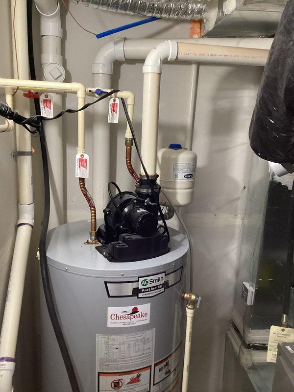 Completed estimate for replacement of existing A.O. Smith ProLine standard water heater with Chesapeake branding. Assessment included evaluation of current installation featuring circulating pump mounted on top unit, copper and PVC supply lines, expansion tank, brass valve connections, and electrical components. Documented existing configuration with multiple pipe connections, safety labels, and mechanical room layout to provide accurate replacement specifications.