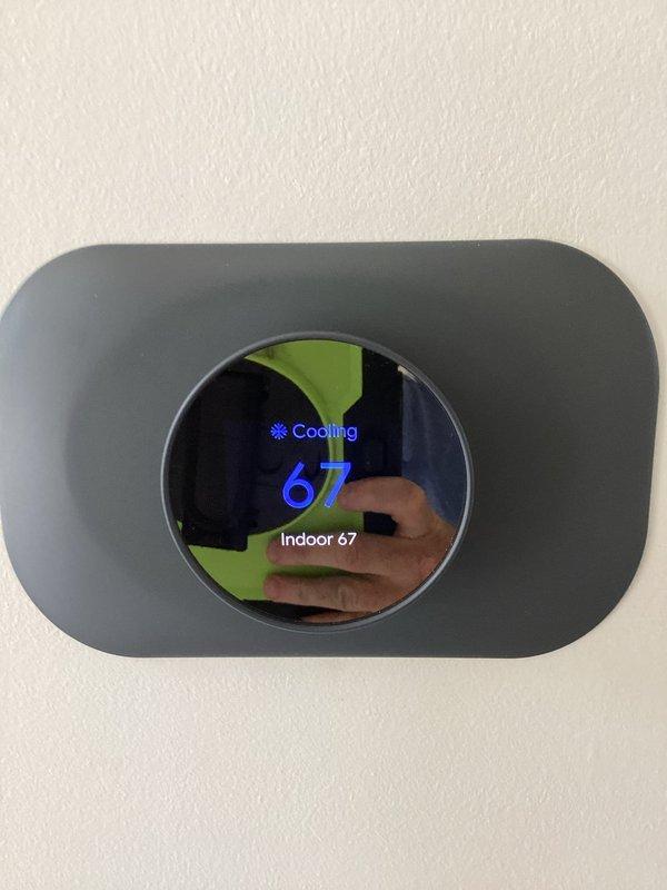 Completed comprehensive system inspection and tune-up on residential HVAC unit. Verified thermostat operation showing cooling mode at 67°F setpoint with proper indoor temperature reading, and measured supply air temperature at approximately 53-54°F at the ductwork, confirming adequate system performance and cooling output within normal operating parameters.