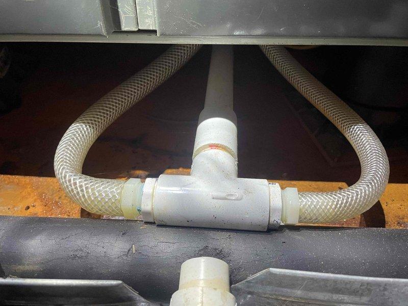 Responded to no cooling call and performed system diagnostics. Inspected attic-mounted air handler and associated ductwork, documenting condensate drain assembly with flexible braided hoses connected to PVC T-joint fitting and noting general system condition. System evaluated and customer advised of findings.