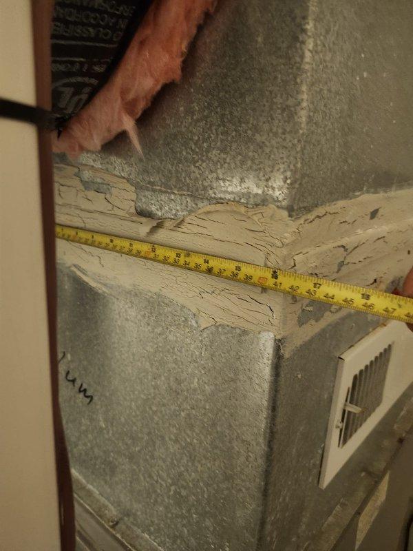 Responded to no cooling call and performed system diagnostics. Upon inspection, discovered deteriorated ductwork and compromised structural support in attic space affecting airflow distribution. Documented extensive cracking and weathering of wooden joists near HVAC components and measured clearances to assess code compliance and safety concerns. Identified white rectangular register connections showing signs of age-related wear that may be contributing to reduced system efficiency and cooling performance.