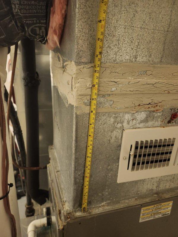 Responded to no cooling call and performed system diagnostics. Upon inspection, discovered deteriorated ductwork and compromised structural support in attic space affecting airflow distribution. Documented extensive cracking and weathering of wooden joists near HVAC components and measured clearances to assess code compliance and safety concerns. Identified white rectangular register connections showing signs of age-related wear that may be contributing to reduced system efficiency and cooling performance.