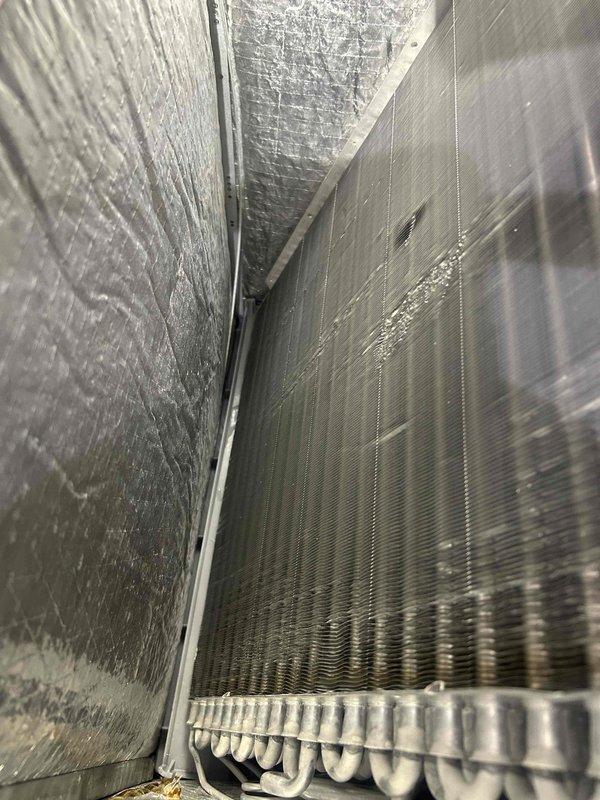 Responded to no cooling call affecting both floors of residence. Upon inspection, accessed air handler and documented evaporator coil condition and refrigerant line configuration. System evaluated and photos taken of interior components including heat exchanger fins, condensate pan, and refrigerant piping for service records.