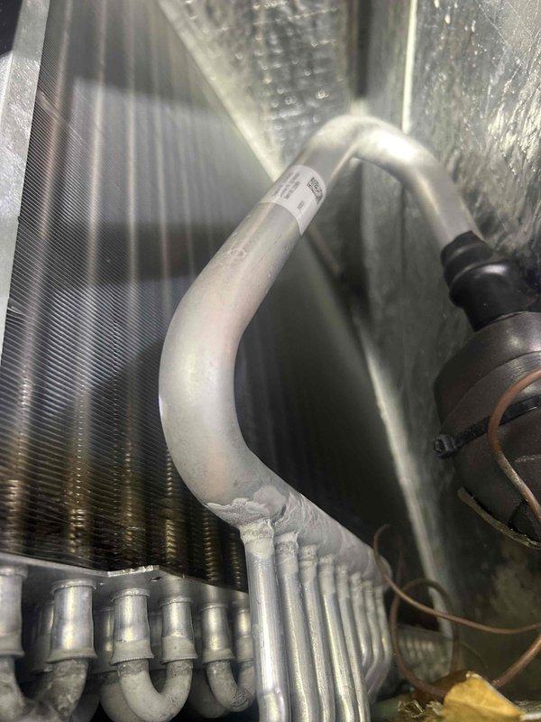 Responded to no cooling call affecting both floors of residence. Upon inspection, accessed air handler and documented evaporator coil condition and refrigerant line configuration. System evaluated and photos taken of interior components including heat exchanger fins, condensate pan, and refrigerant piping for service records.