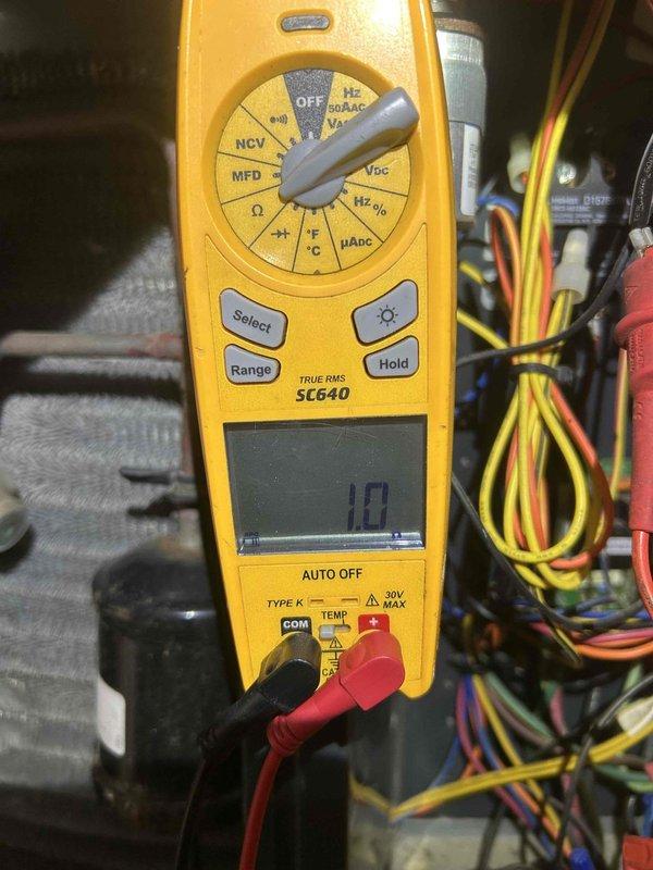 Responded to no cooling call affecting entire main floor. Upon arrival, found air conditioning system completely non-operational. Performed diagnostic testing using digital multimeter to measure capacitor values on outdoor condensing unit. Readings indicated dual run capacitor had failed, measuring 10 microfarads on one terminal and 15 microfarads on the other, both below manufacturer specifications. Replaced defective capacitor with proper OEM replacement, restored power to unit, and verified system operation with all electrical components functioning within normal parameters. System now cooling properly throughout affected areas.