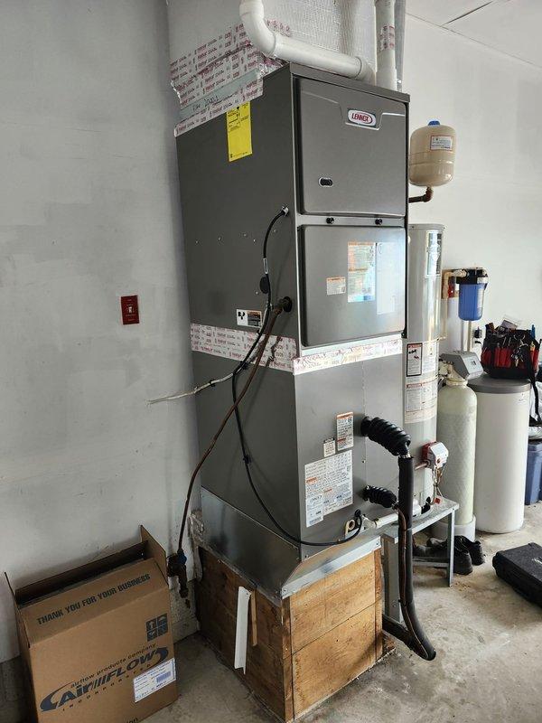 Completed full HVAC system replacement including removal and disposal of existing equipment. Installed Lennox ML296DF090XV60C variable speed two-stage furnace with LP conversion kit in garage, added filter rack to furnace assembly. Installed CK40DT-50/60C evaporator coil and ML16KP2-048 two-stage heat pump outdoor unit on platform with new whip and disconnect. Flushed, pressure tested, and recharged refrigeration lines to manufacturer specifications. Installed THX1200W WiFi thermostat for system control. Verified draft pressure readings at 4.97 inches water column. System commissioned and operational with one-year comprehensive warranty coverage.