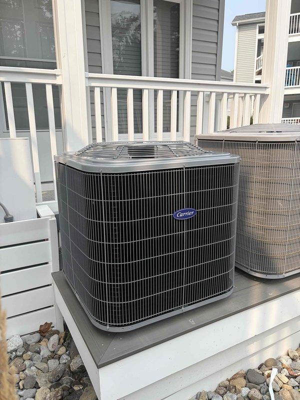 Completed full HVAC system replacement including removal and disposal of existing equipment. Installed new Carrier 26SCA518A003 1.5-ton 15 SEER air conditioning condenser unit on existing outdoor stand with decorative river rock landscaping. Mounted new Carrier FJ5ANXB18L00 air handler indoors with filter at unit. Fabricated and installed metal duct transitions to adapt new equipment to existing ductwork. Replaced outdoor electrical disconnect and whip while reusing existing electrical service, condensation drain lines, and refrigerant line sets. Installed Honeywell Home digital WiFi thermostat with programmable controls, humidity monitoring, and air quality display. Verified system operation with unit cooling properly to setpoint. Installation includes one-year parts and labor warranty from installation date.