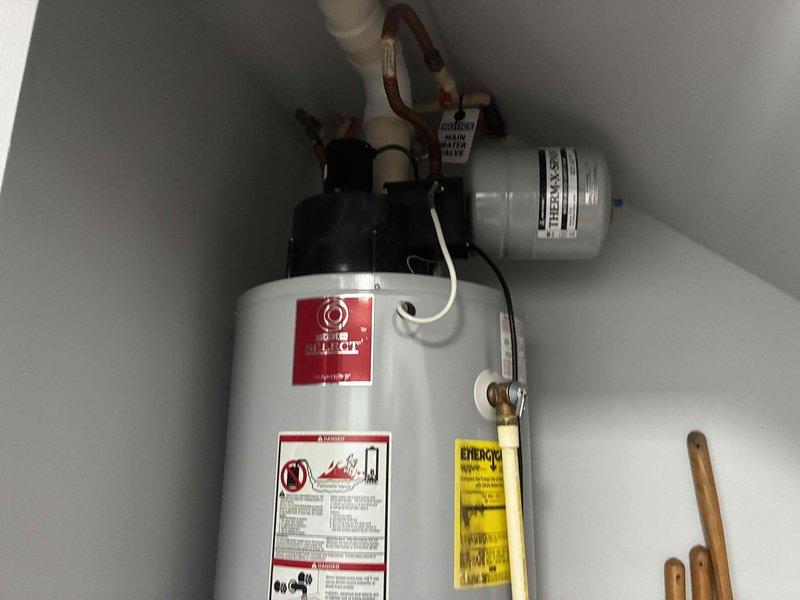 Completed estimate for residential water heater replacement. Evaluated existing propane-fired State brand water heater installation in utility closet, documenting current configuration including yellow flexible gas lines, copper supply piping, expansion tank, and venting system. Assessed feasibility of conventional tank replacement versus tankless conversion, photographing existing plumbing connections, gas line routing, electrical components, and spatial constraints within confined installation area for customer review and proposal preparation.