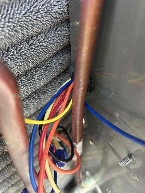 Responded to no cooling complaint on residential HVAC system. Upon inspection, measured supply air temperature at 53°F indicating inadequate cooling performance. Investigated refrigerant lines and electrical connections at the air handler, checking for proper voltage, secure wire connections, and refrigerant line integrity. Verified all electrical wiring was properly routed and secured, with no visible damage to copper refrigerant tubing or insulation.