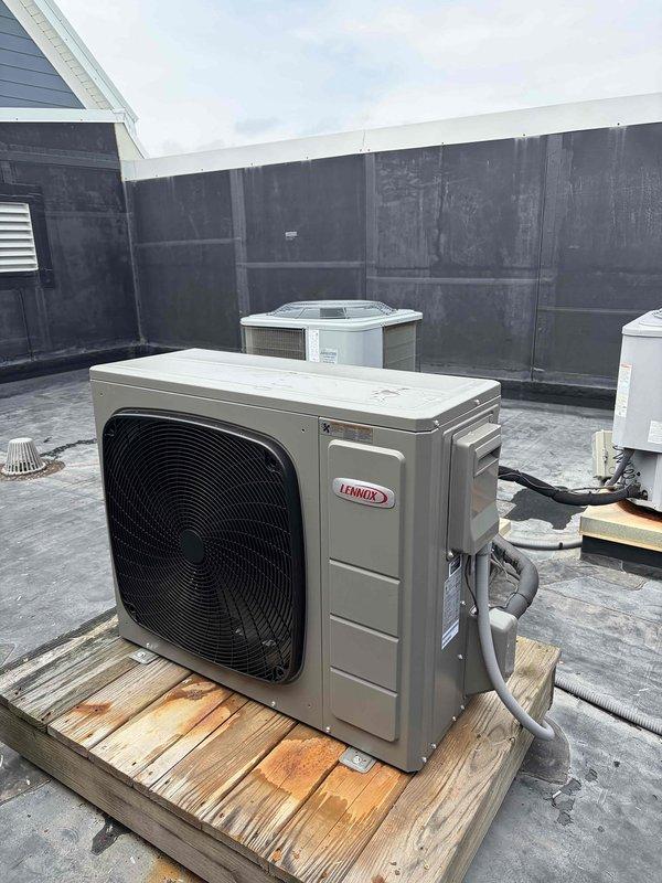 Completed full HVAC system replacement on rooftop installation, removing and disposing of existing equipment. Installed new Lennox ML15KSPV-036 3-ton 16 SEER heat pump condensing unit on wooden platform, Lennox CBK45UHVT-036 variable speed air handling unit, and Lennox ECB45 10kw electric heat pack. Fabricated and installed metal duct transitions to adapt new equipment to existing ductwork. Replaced outdoor disconnect and electrical whip while reusing existing electrical service, condensation drain lines, and refrigerant line sets. Secured outdoor unit on elevated platform per installation specifications. Reused existing thermostat and verified system operation with proper airflow and temperature differential across all zones.