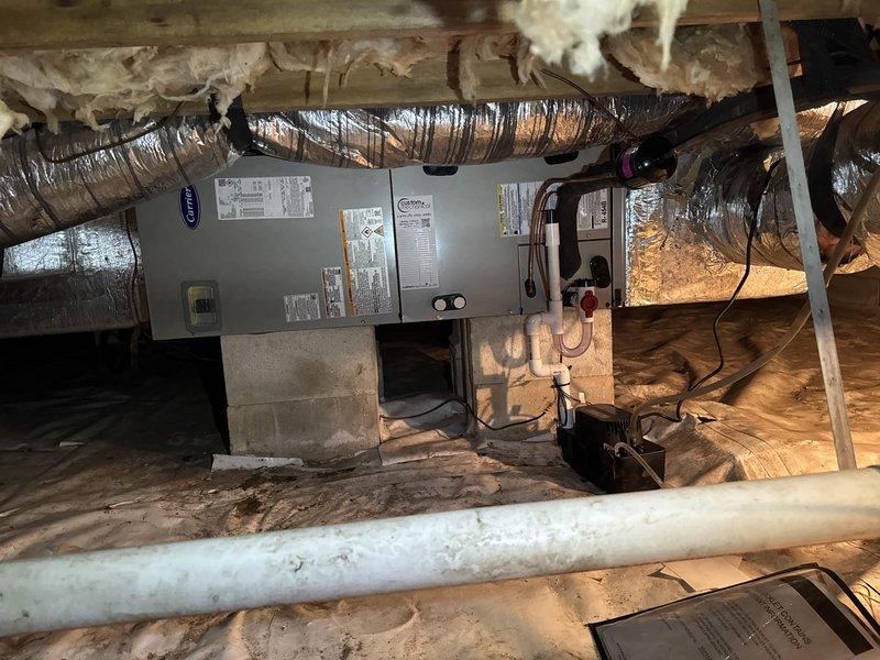Completed full system replacement including removal and disposal of existing HVAC equipment. Installed new Carrier 27SCA530A003 2.5-ton 15 SEER heat pump with outdoor unit mounted on pressure-treated wood platform, Carrier FJ5ANXB30L00 air handler in crawl space, and Carrier 10kw electric heat pack. Fabricated and installed metal duct transitions to adapt new equipment to existing ductwork. Replaced outdoor disconnect and electrical whip while reusing existing electrical service, condensate drain lines, and power connections. Installed Honeywell TH6320WF digital WiFi thermostat for system control. Secured air handler on concrete block supports with proper clearances, verified all electrical connections meet code requirements, tested condensate drainage system, and confirmed proper airflow through adapted ductwork. System commissioned, tested for proper operation in heating and cooling modes, and filter installed at unit. Customer enrolled in one-year platinum comprehensive maintenance 