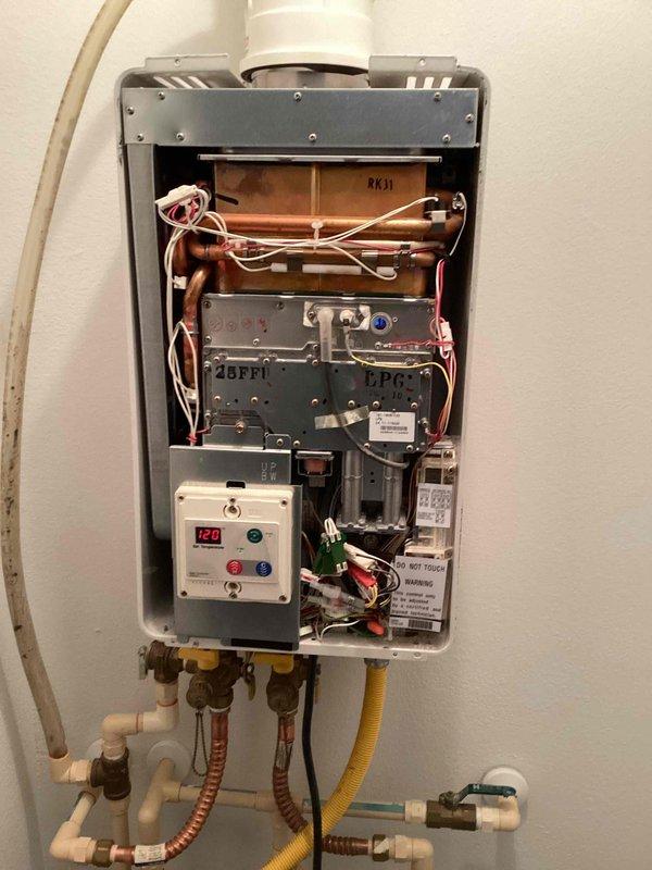 Responded to no hot water complaint at rental property. EverHot tankless water heater displayed error code 11 indicating ignition failure. Removed front cover and performed diagnostic inspection of internal components. Inspected heat exchanger, copper piping, control boards, electrical connections, and gas supply line. Identified ignition system malfunction preventing unit from firing. Cleared error code, tested gas flow through yellow flexible gas line, verified proper venting through PVC exhaust pipe, and checked all water inlet/outlet connections with brass shut-off valves. Restored unit to proper operation and confirmed hot water delivery. System tested and operational upon departure.