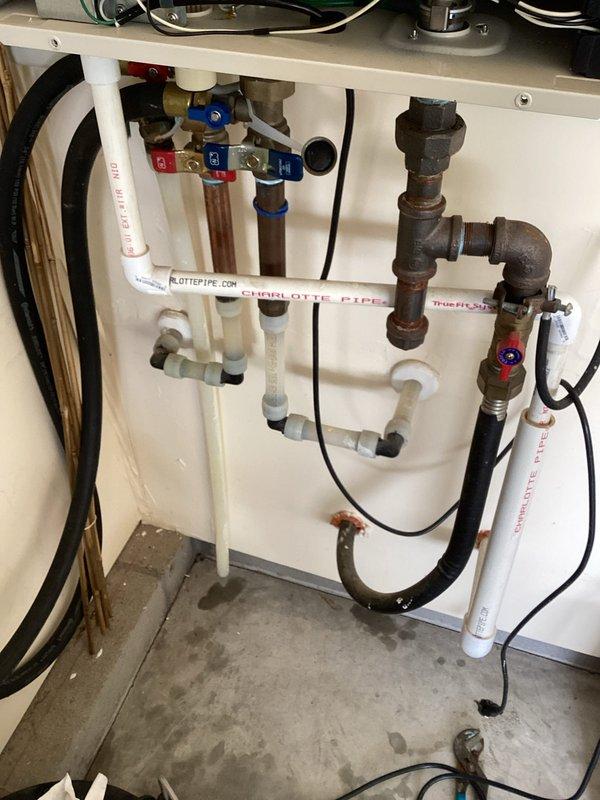 Completed preventive maintenance visit on Noritz NRC98DV tankless water heater unit rated at 180,000 BTU maximum output. Inspected all plumbing connections including copper supply lines with brass ball valves, PVC drain and vent lines, and verified proper operation of isolation valves. Documented existing installation configuration showing water supply piping, gas connections, and electrical components all functioning within manufacturer specifications. Unit tested and confirmed operational for continued service.